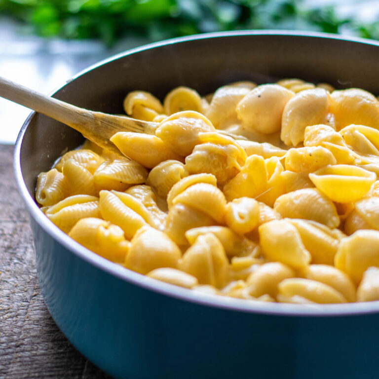 Pasta in a bowl with a wooden spoon